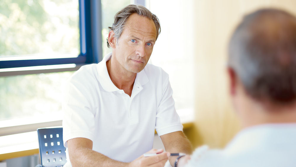 Doctor talks with patient about thoracic and lumbar spine surgery