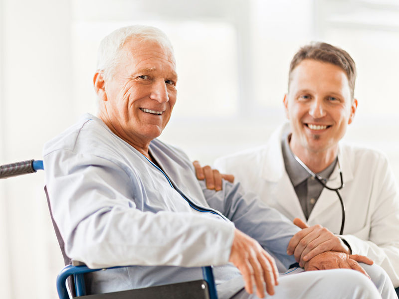 Male patient in a hospital with a male doctor laughing together