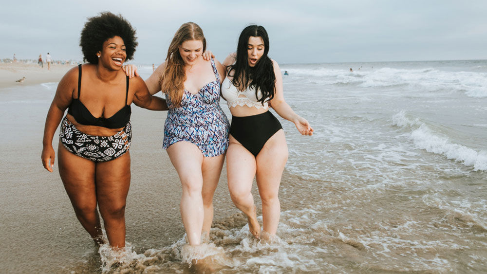 Three young ladies on the beach, feet in the water: I like to spend time with my friends at the beach.