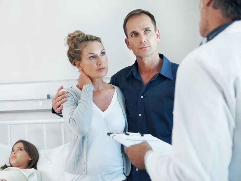 Parents in discussion with a doctor about their daughter in a hospital