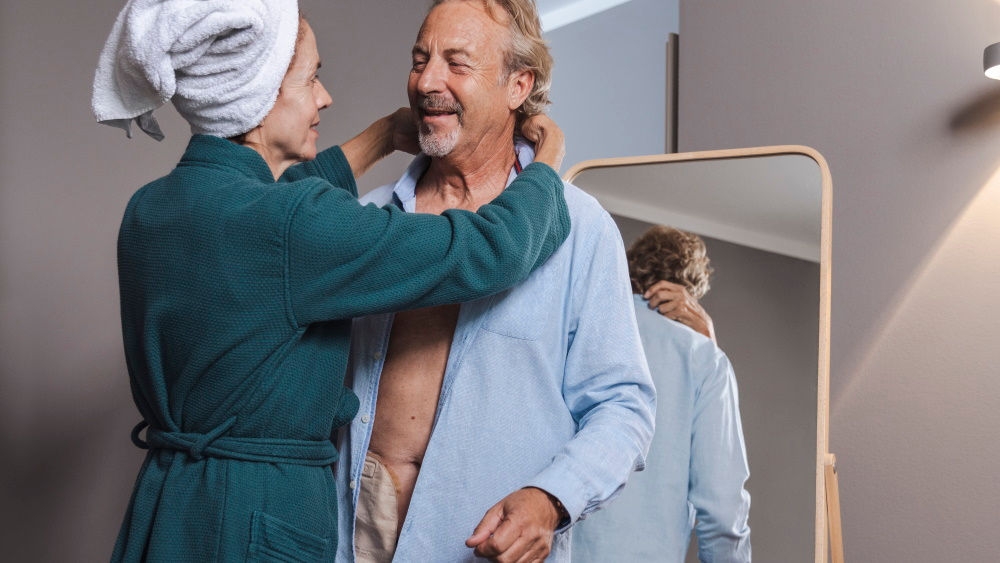 Wife in green bathrob hugs husband