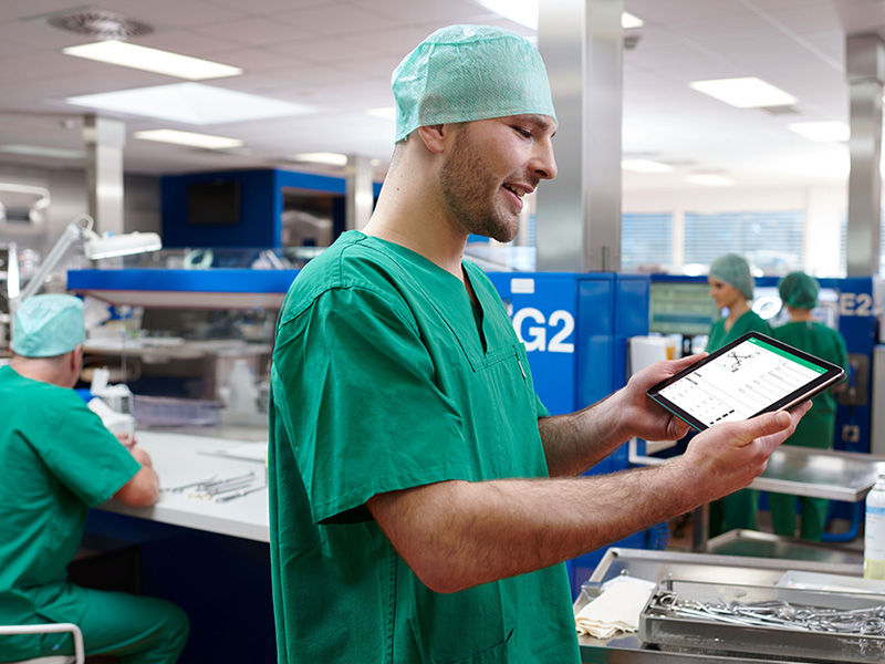 Young CSSD employee with a digital tray organizing management tool on his tablet