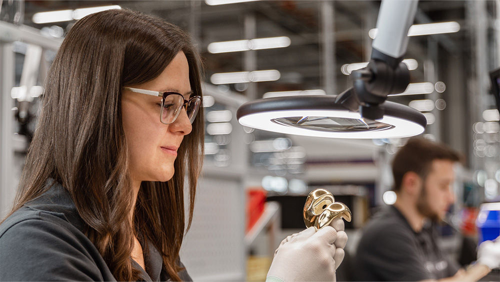 Young woman manufacturing a knee arthroplasty implant