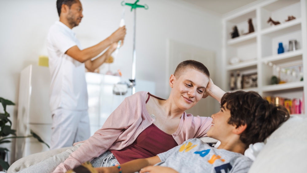 woman who lies near her child with nurse in the background