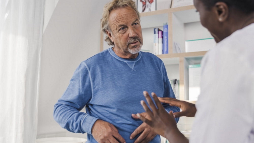 elderly man in blue shirt with stoma nurse