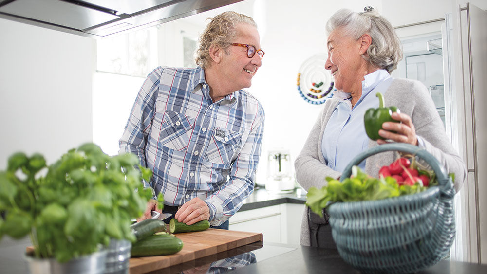 man and woman prepare vegetables together